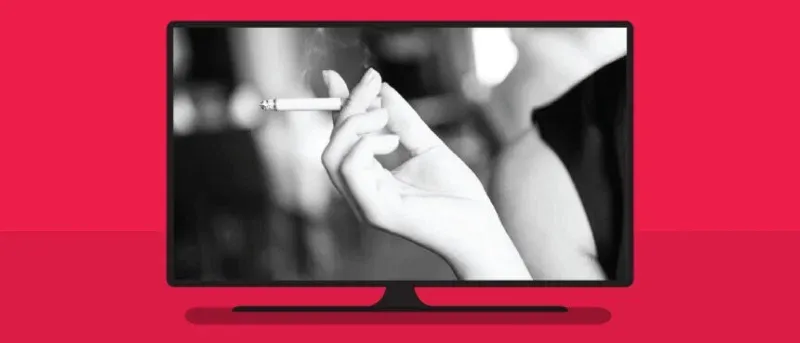 A TV screen on a red background, displaying a black-and-white image of a hand holding a lit cigarette.